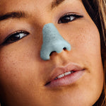 Load image into Gallery viewer, Woman wearing blue NOZ sunscreen on face
